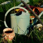 white and brown watering can on green grass