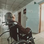 woman in black and white long sleeve shirt sitting on black wheelchair